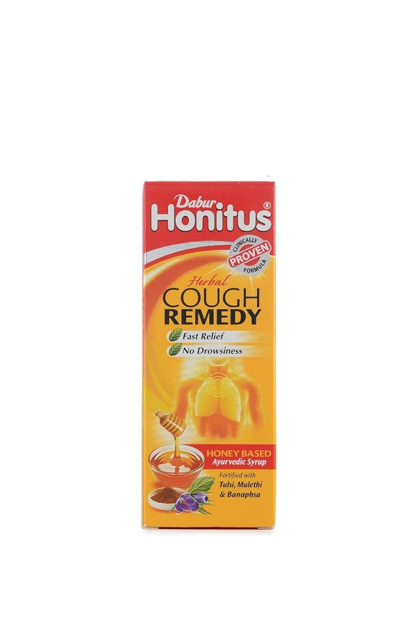 Herbal cough remedy syrup bottle labeled "Dabur Honitus" with a 100ml capacity, placed on a wooden surface.