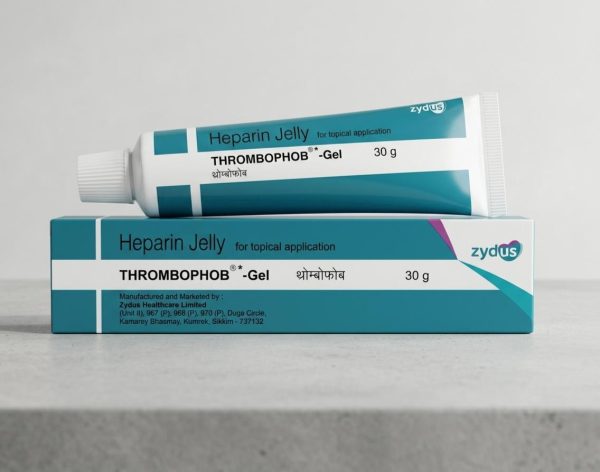 A tube of Zydus Heparin Jelly Thrombophob Gel 30gm placed beside a tube of thermometer gel on a neutral background.