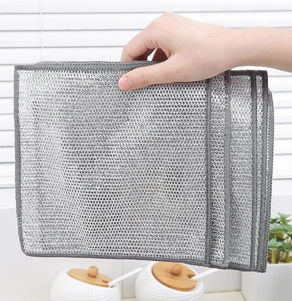 A person holds a mesh bag with a silver handle, containing ten metal steel wire cleaning cloths for kitchen use.
