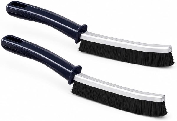 Two durable grout cleaning brushes, one black and one white, displayed on a white surface for tile and corner cleaning.