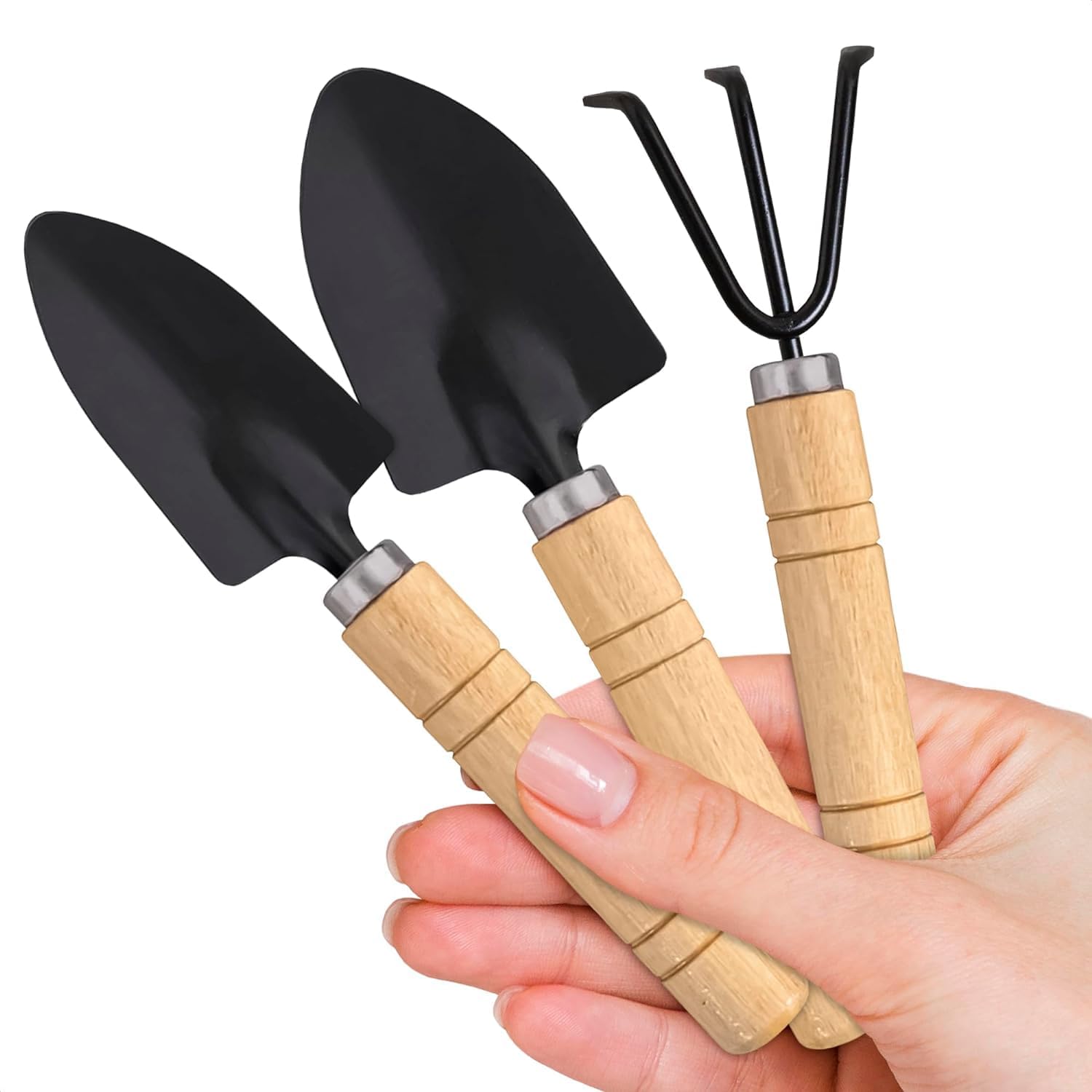 57 (1) Three wooden-handled garden tools: spade, shovel, and rake, held together in a hand against a blurred background.